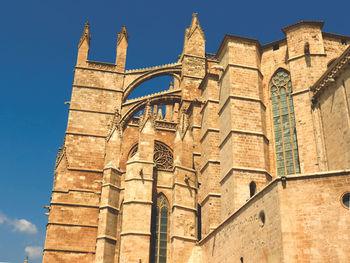 Low angle view of historical building against clear blue sky