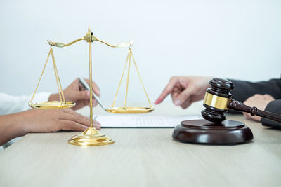 Cropped hands of lawyer pointing to documents for signing