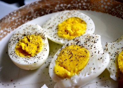 High angle view of pepper on boiled eggs in plate