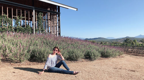 Full length portrait of woman sitting on field