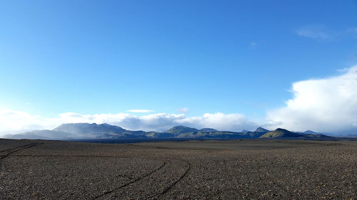 Scenic view of desert against blue sky