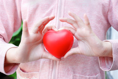 Close-up of woman holding heart shape