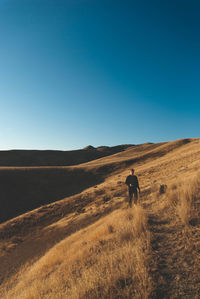Man standing at desert against clear sky