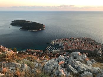 High angle view of rocks by sea against sky