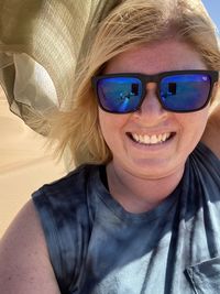 Portrait of a smiling young woman wearing sunglasses