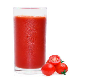 Close-up of drink with cherry tomatoes against white background