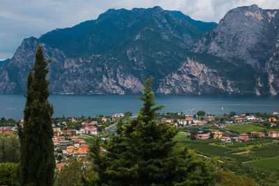 Scenic view of town by sea and mountains against sky