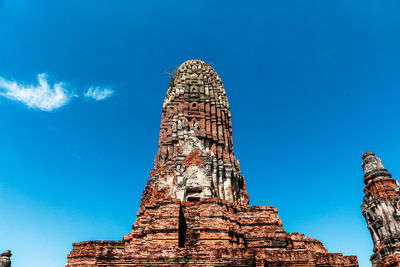 Low angle view of old temple building against blue sky