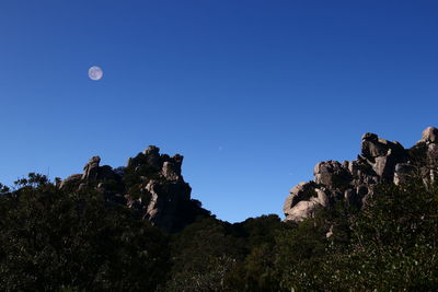 Low angle view of rock formation against clear blue sky