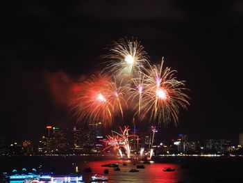 Firework display over river at night