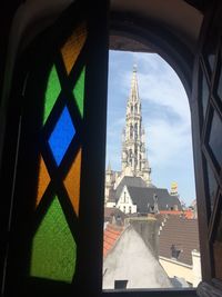 Buildings against sky seen through window