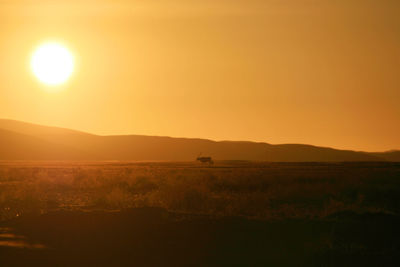 Scenic view of silhouette field against clear sky during sunset