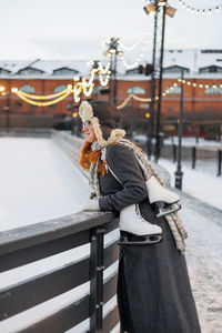 Rear view of woman standing by railing