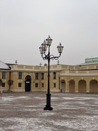 Street light by building against sky