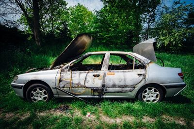 Abandoned car on grassy field