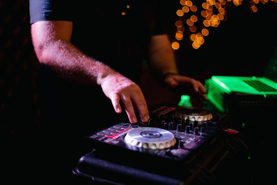 Dj playing music. sound mixer panel and cd players turntables with illuminated buttons and dj hands