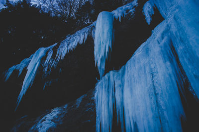 Low angle view of icicles against mountains during winter