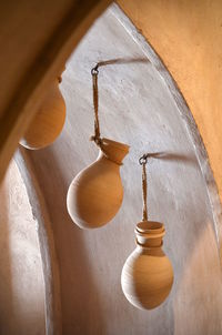 Low angle view of electric lamp hanging against wall