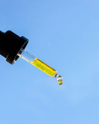 Low angle view of telephone pole against clear blue sky