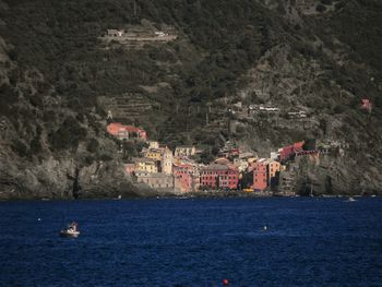 Sailboats in sea with buildings in background