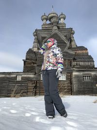 Low section of man standing on snow covered building