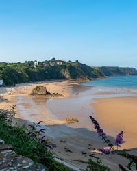 Scenic view of beach against clear blue sky