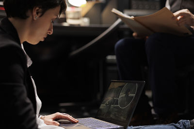 Close-up of woman using laptop at table