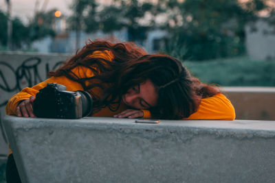 Side view of young woman sitting on street