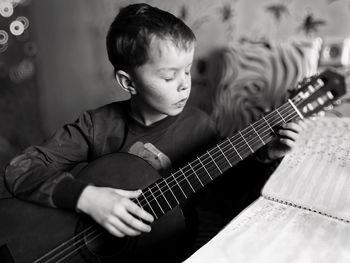 Boy playing guitar at home