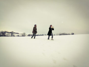 People on snow covered against sky