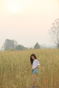 Woman standing on field against sky