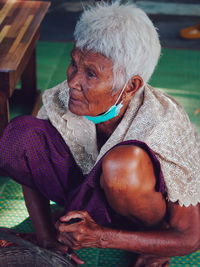 Side view of young woman sitting on table