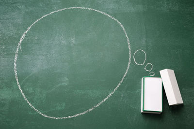 Containers with speech bubble on blackboard