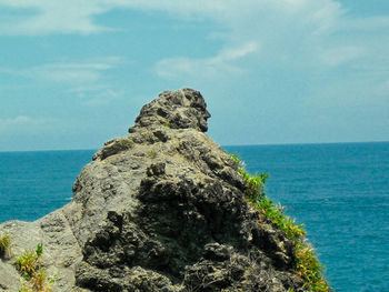 Rock formation on sea against sky