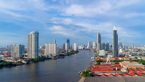 View of buildings in city against cloudy sky