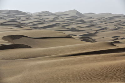 Sand dunes in desert against sky