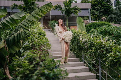 Young girl in a golden dress with a bouquet of white roses