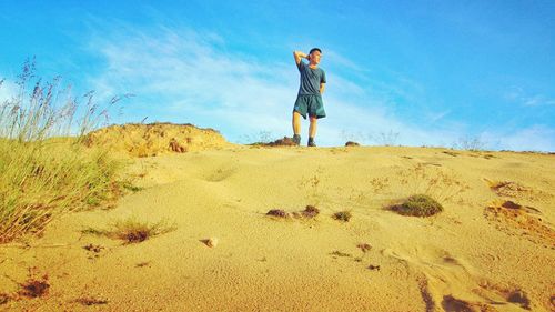 Rear view of woman walking on sand