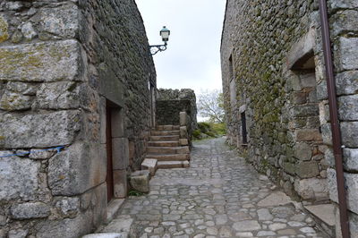 Cobblestone street amidst buildings against sky