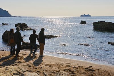 People on beach against sky