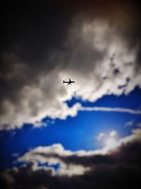 Low angle view of silhouette airplane flying in sky