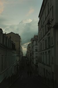 Buildings in city against cloudy sky