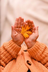 Midsection of children holding autumn  leaf