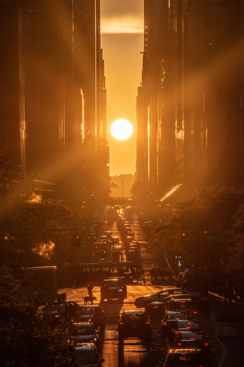 STREET BY BUILDINGS AGAINST SKY DURING SUNSET