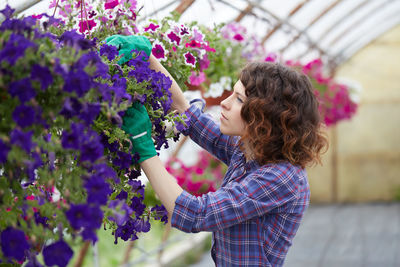 Woman holding flower pot at greenhouse
