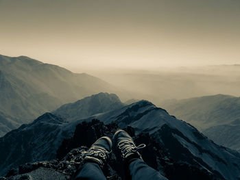 Low section of man on mountain against sky