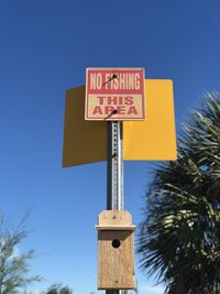 Low angle view of road sign against sky