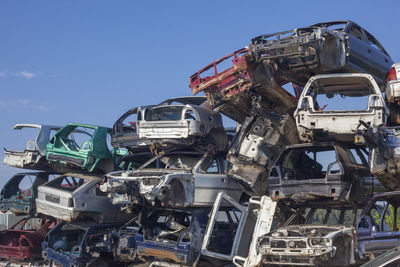 Abandoned cars in junkyard against sky
