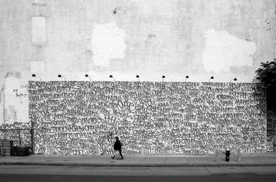 People on wall against sky