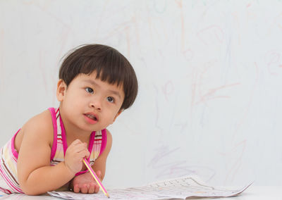 Portrait of a smiling girl holding table